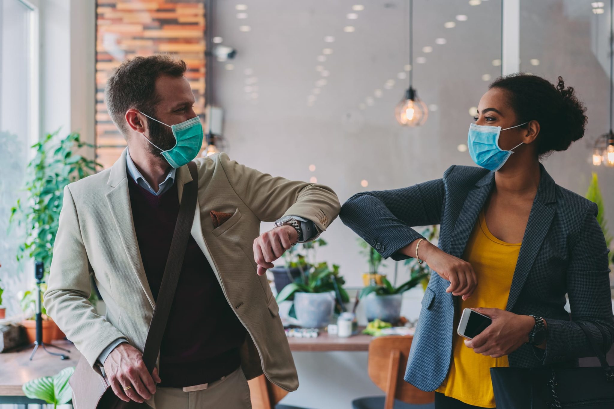 Business people greeting during COVID-19 pandemic, elbow bump Colleagues in the office practicing alternative greeting to avoid handshakes during COVID-19 pandemic