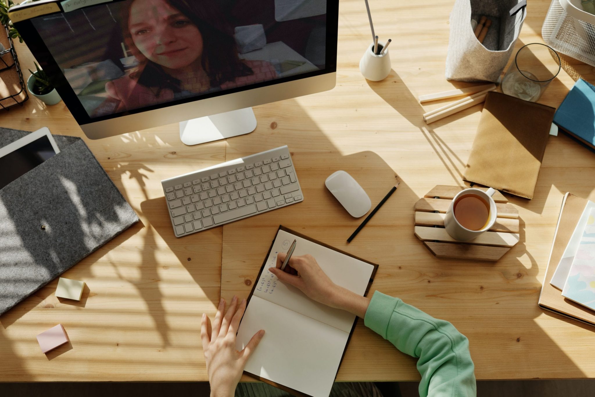 Woman taking notes during a virtual event.