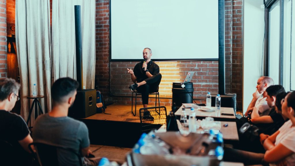 Man on stage speaking at an event.