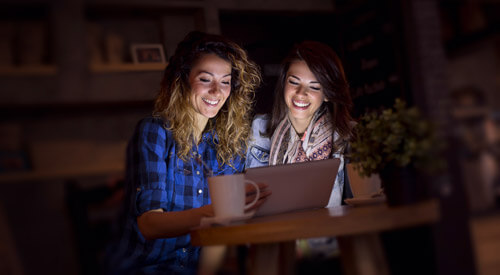 Two women staring at a laptop