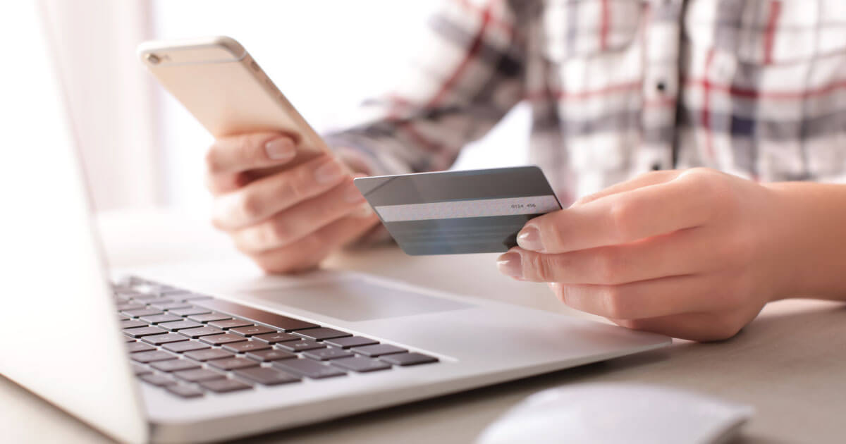 Man viewing credit card information while using a laptop