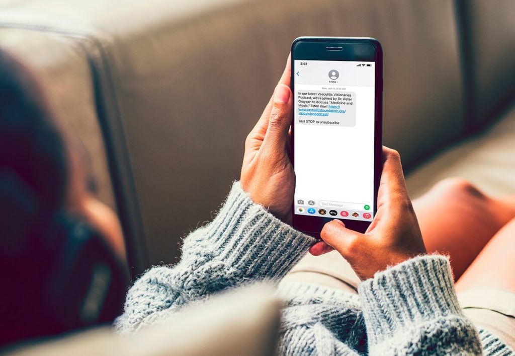 Girl holding phone with Vasculitis Foundation text message on screen