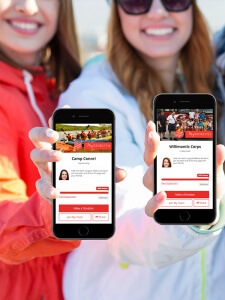 Two women holding up their phone screens to show their donation profiles