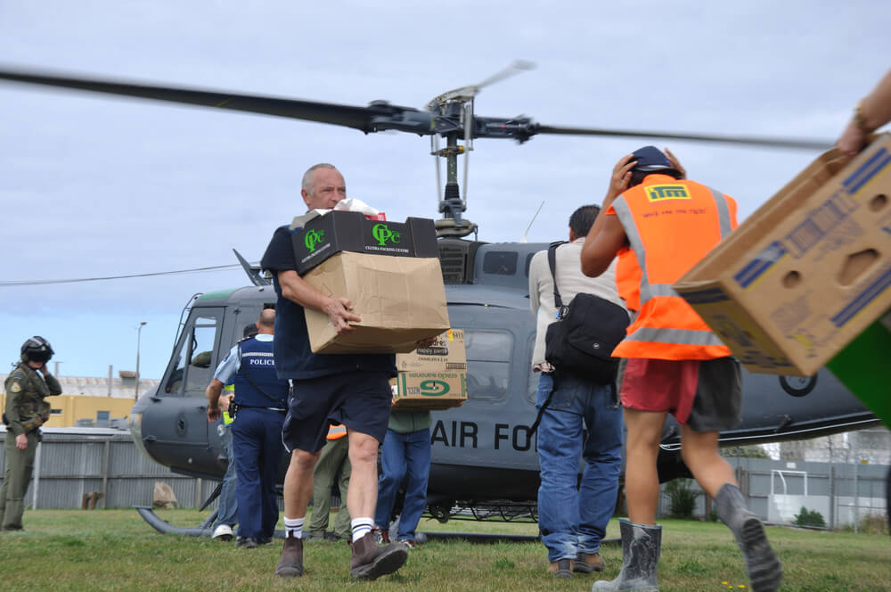 Workers carrying boxes to and from air force helicopter