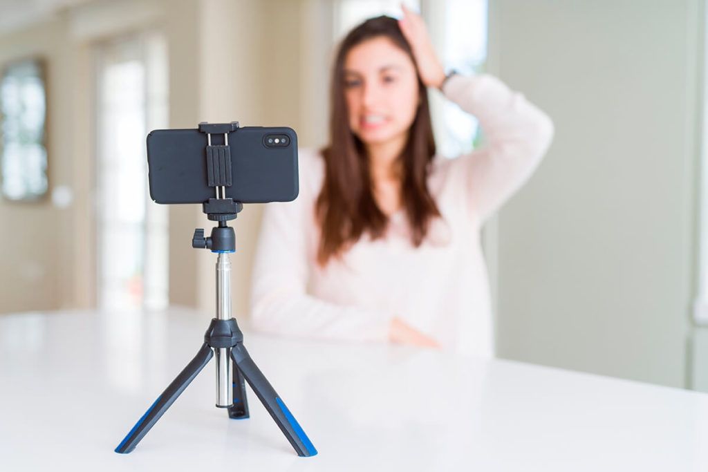 Woman posing in front of a phone mounted on a stand