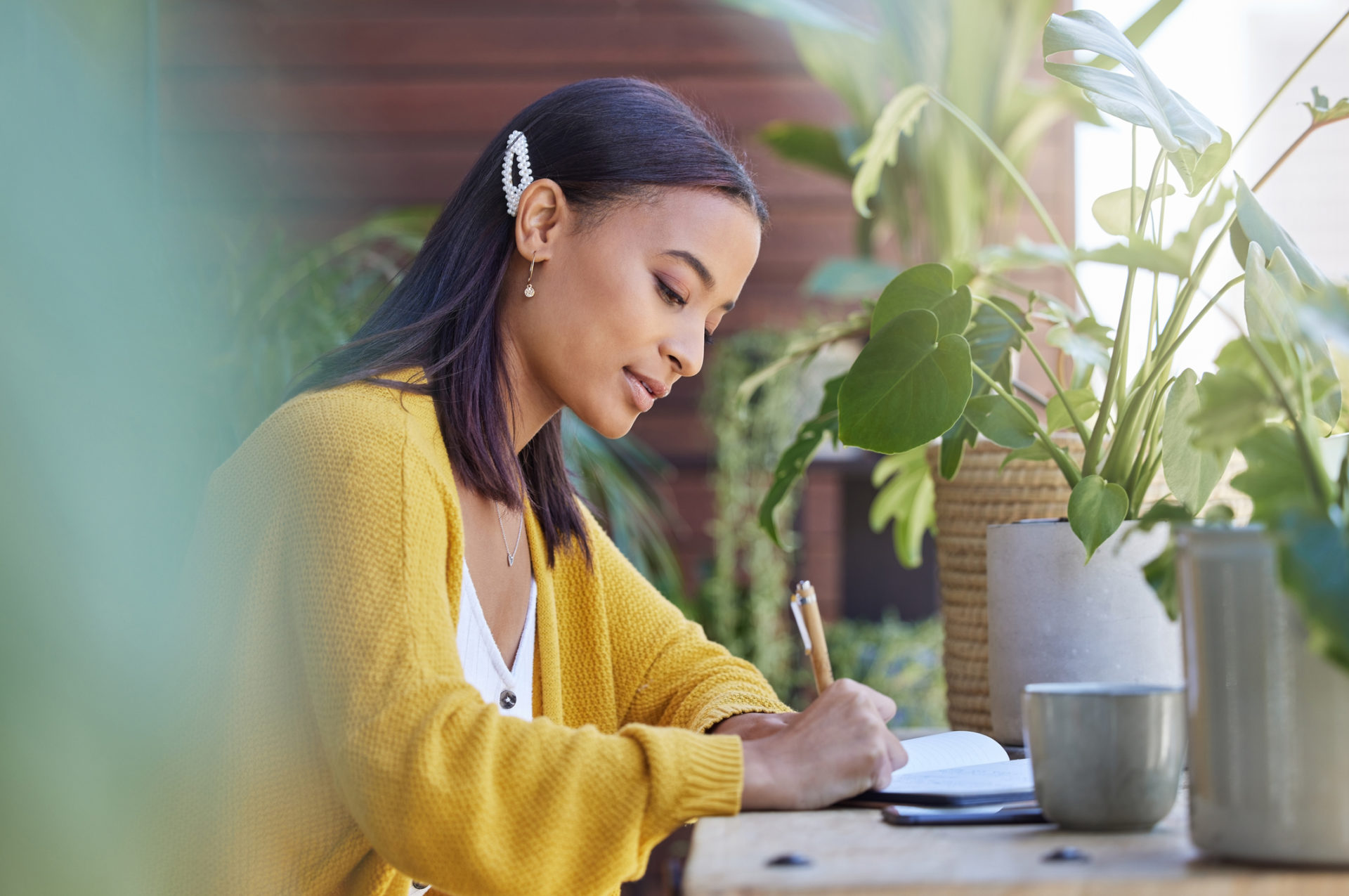 Shot of a young businesswoman working on the balcony at home