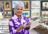 Woman with short gray hair looking at items in a silent auction